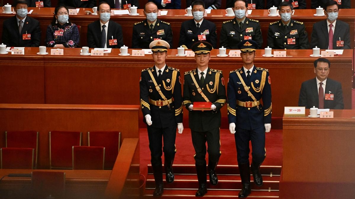 PLA soldiers stand in front of a copy of China's constitution as they prepare for Jinping to swear an oath after being re-elected for a third term during the third plenary session of the National People's Congress (NPC) in Beijing. Credit: AFP Photo