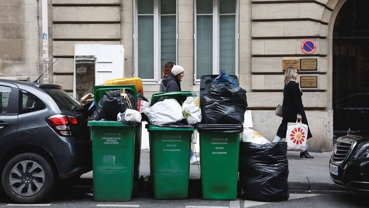 People walk on a street where garbage cans are overflowing, in Paris. France lags most of its European neighbours, which have hiked the retirement age to 65 or above. Its spending on pensions is the third highest among industrialised countries, at the equivalent of 14.5 percent of GDP. Credit: Reuters Photo