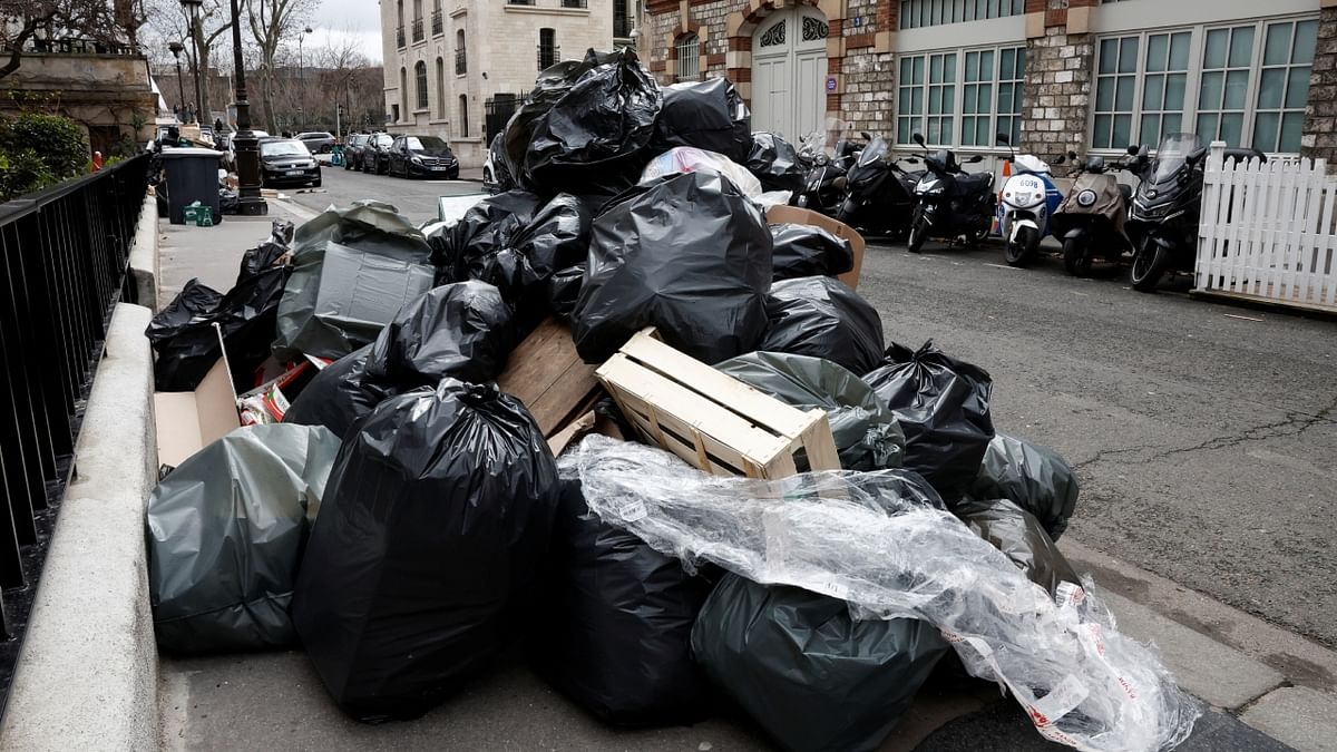 A view of a street where garbage cans are overflowing, Paris. Macron's proposal to make people work longer is deeply unpopular amongst the wider public, opinion polls show. Credit: Reuters Photo