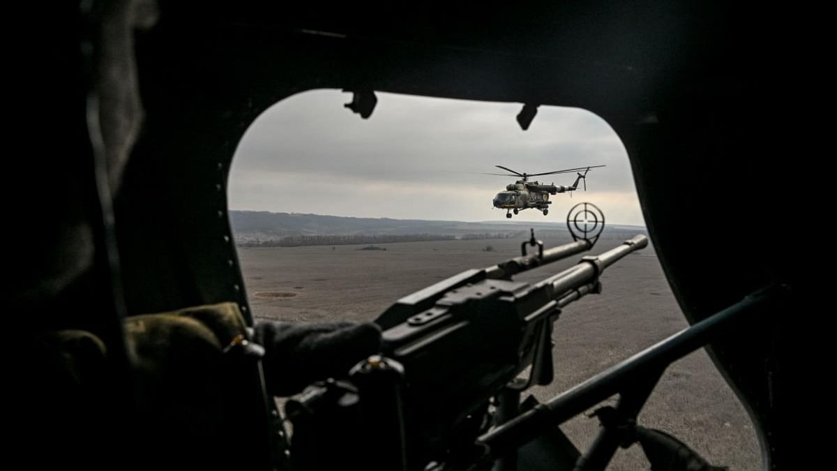 A Ukrainian door gunner watches a second Mil Mi-8 helicopter as he flies in eastern Ukraine. Credit: AFP Photo