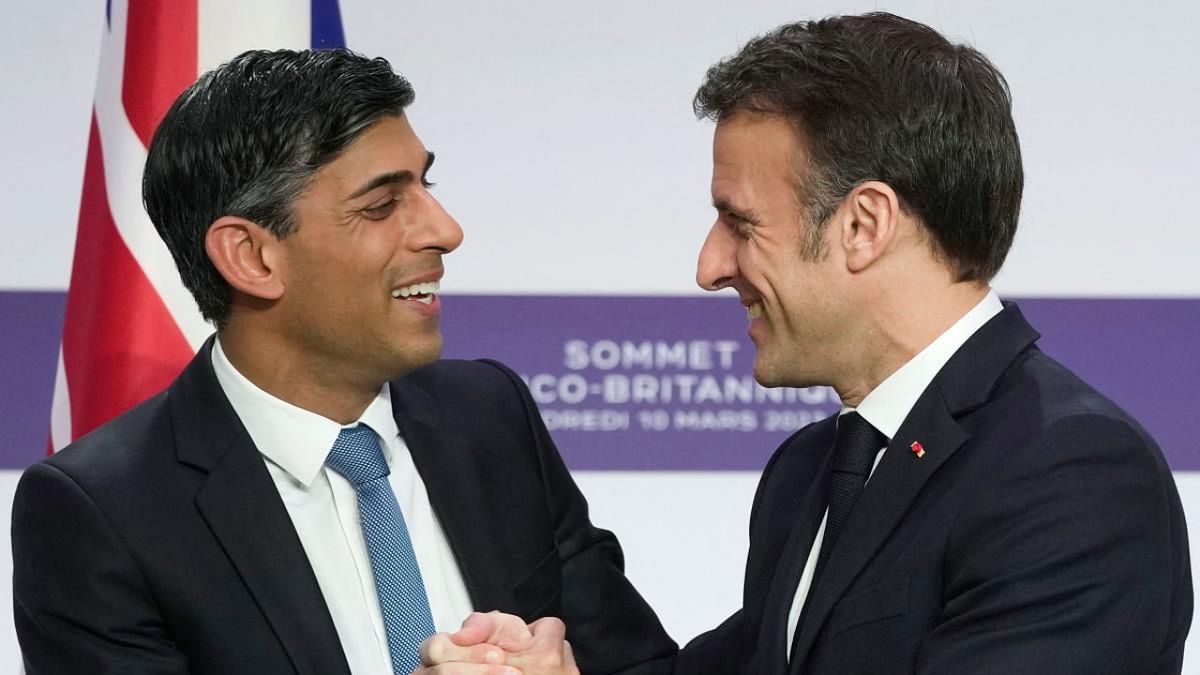 Britain's Prime Minister Rishi Sunak (L) and France's President Emmanuel Macron (L) react as they shake hands during a joint press conference at the end of the French-British summit, at the Elysee Palace, in Paris. Credit: AFP Photo