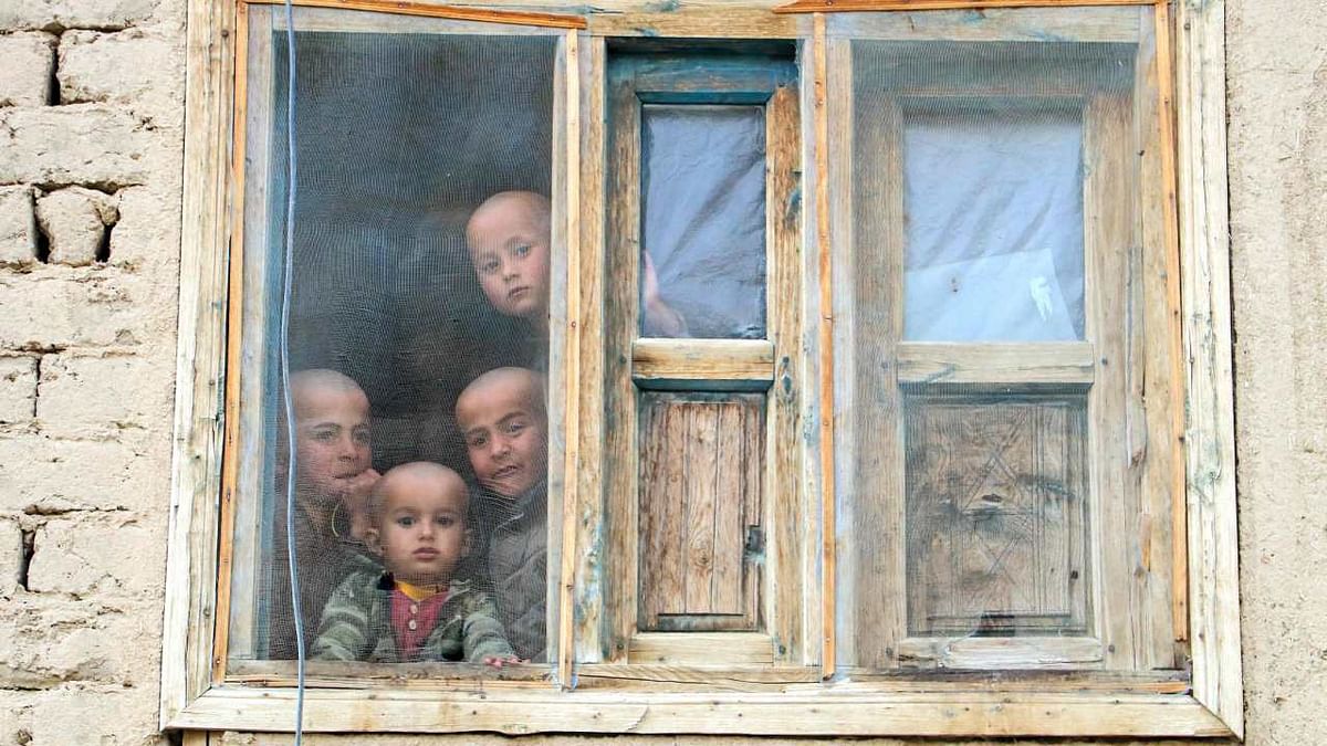 Afghan boys look from a window of their house in Yaftal Sufla district of Badakhshan province. Credit: AFP Photo