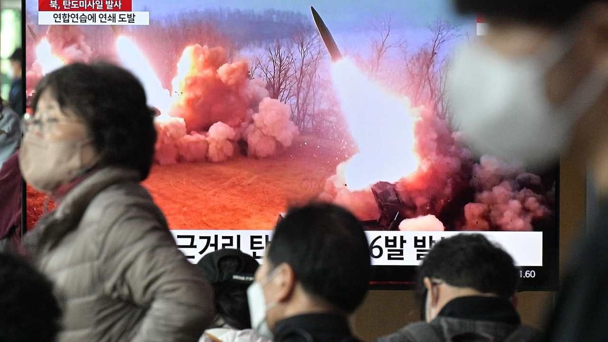 People walk past a television screen showing a news broadcast with file footage of a North Korean missile test, at a railway station in Seoul. Credit: AFP Photo