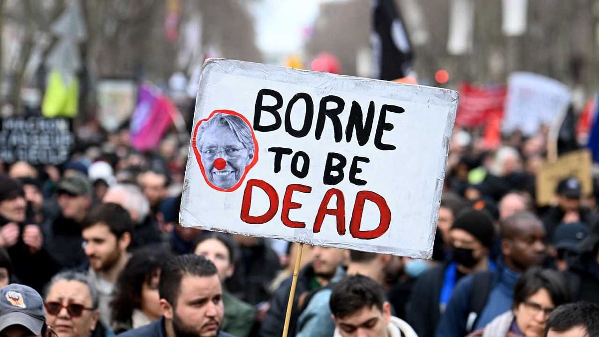 Protestors hold a slogan bearing a mocking portrait of French Prime Minister Elisabeth Borne during a demonstration on a 8th day of strikes and protests across the country against the government's proposed pensions overhaul in Paris. Credit: AFP Photo