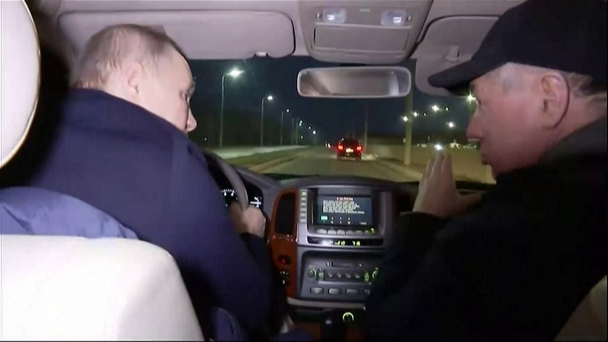 In this grab taken from video released by Russian broadcaster VGTRK as POOL on March 19, 2023, shows Russia's Vladimir Putin (L) driving with Deputy Prime Minister Marat Khusnullin as he visits the Ukranian city of Mariupol late March 18, 2023. Credit: AFP Photo