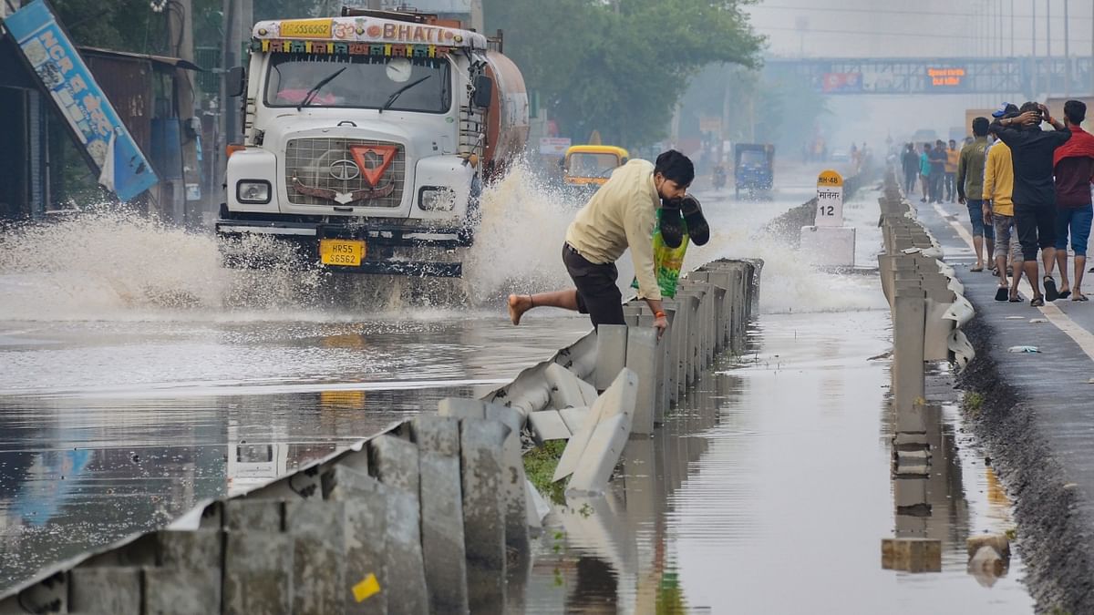 Heavy rain lashed parts of the national capital on Monday evening, sending people scurrying for cover. Commuters also faced waterlogging and traffic snarls while navigating the roads. Credit: PTI Photo