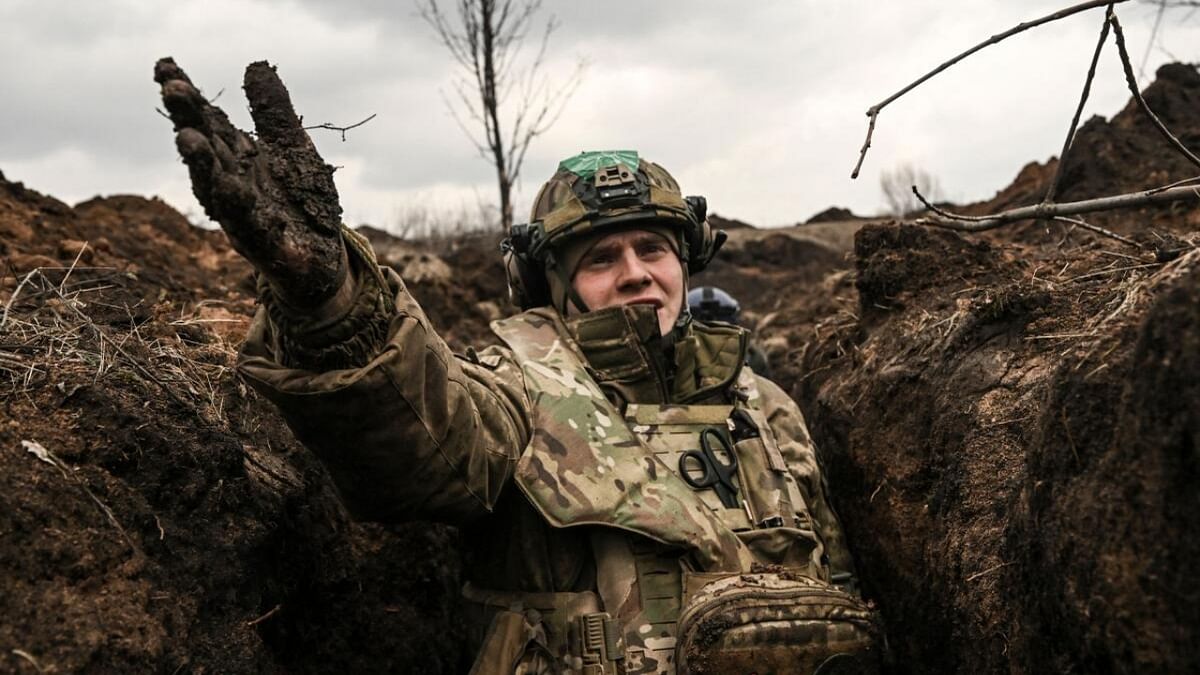 A Ukrainian serviceman takes cover in a trench near Bakhmut in the Donbas region on March 8, 2023. Credit: AFP Photo