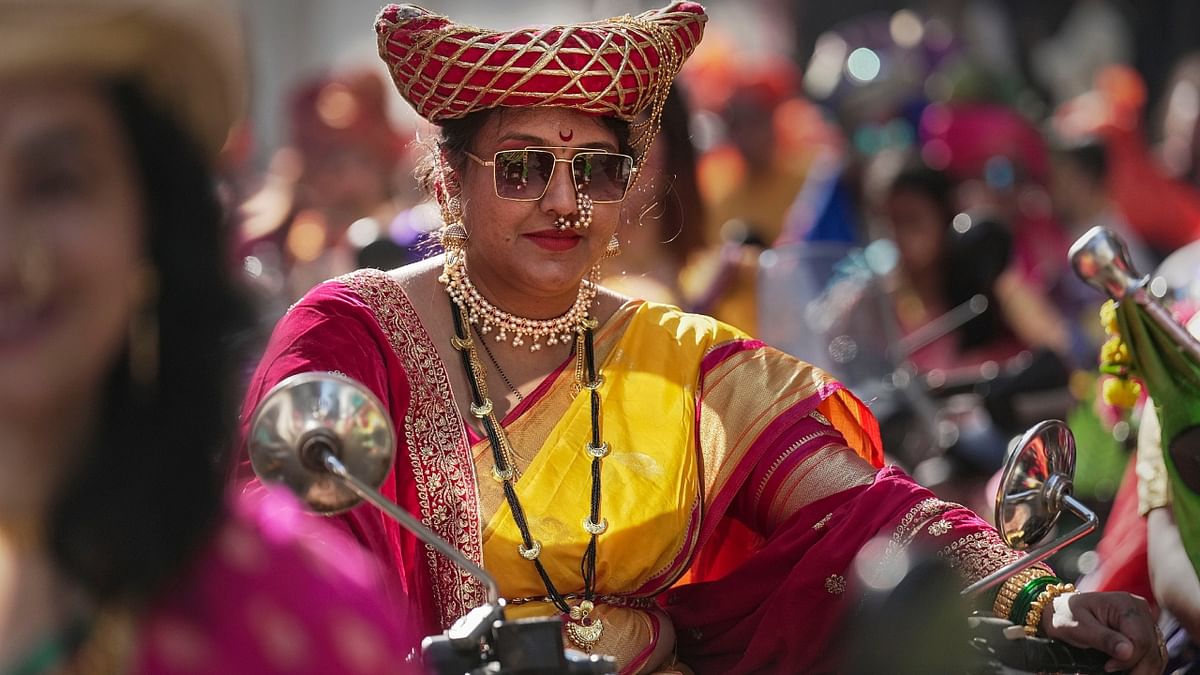 A woman dressed in traditional attire rides a bullet during  the Gudi Padwa procession in Mumbai. Credit: PTI Photo