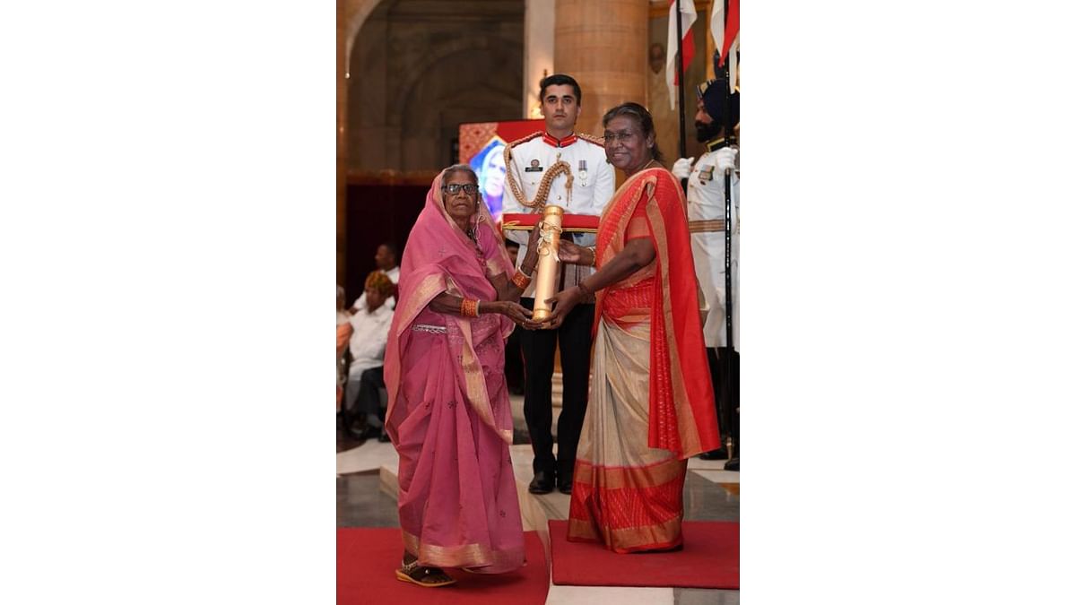President Droupadi Murmu presents the Padma Shri award to Jodhaiya Bai Baiga in the 'Art' category. A prominent artist of the Baiga style of painting, she helped bring recognition to the traditional work, philosophy, and culture of the Baiga Tribe. Credit: Special Arrangement