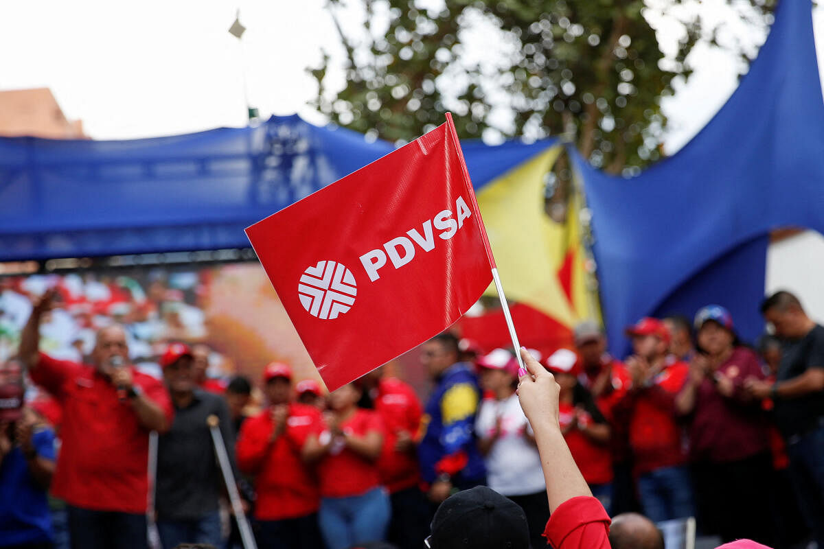 A woman holds a flag of the Venezuelan state oil company PDVSA while attending a rally against corruption and in support of the oil industry in Caracas. Credit: Reuters Photo