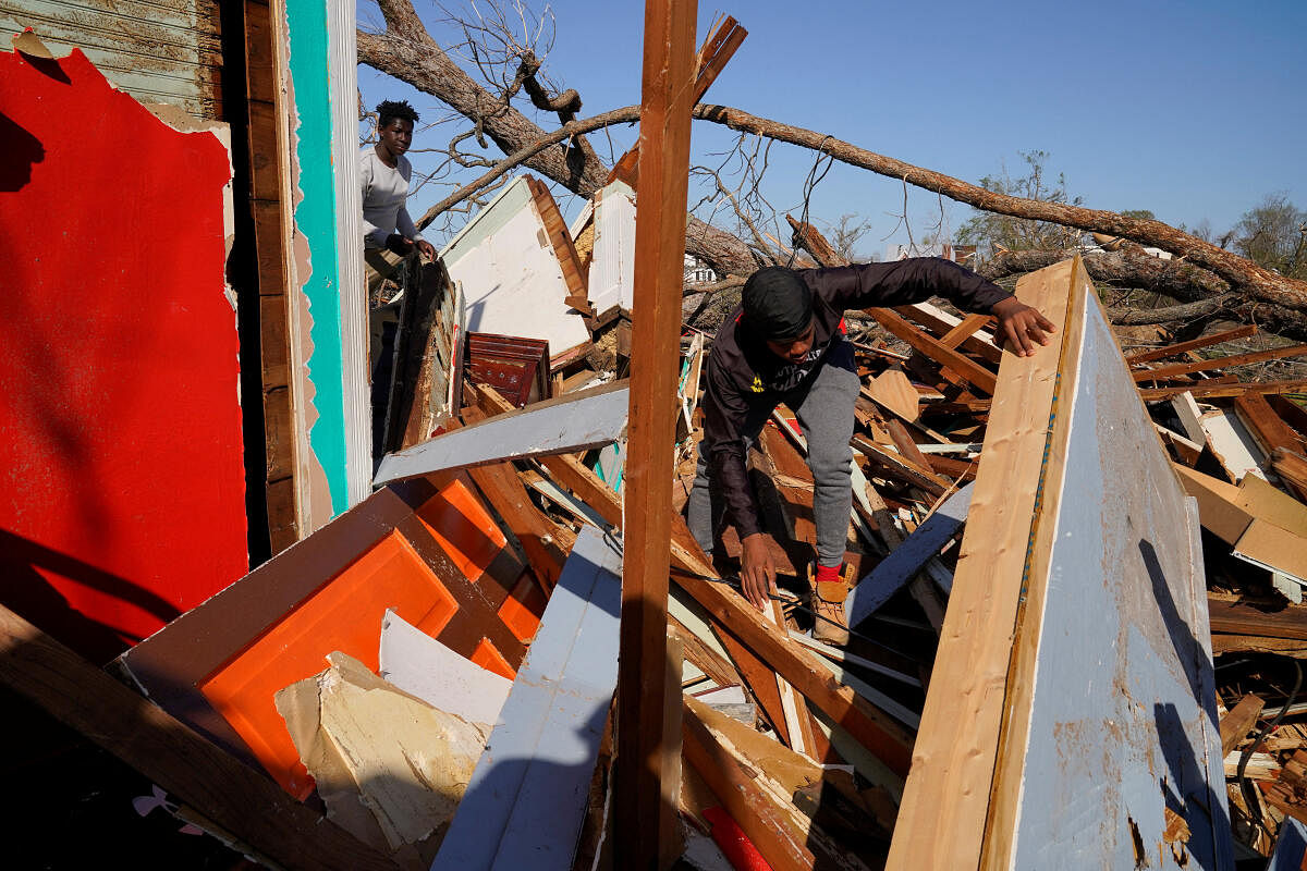 The son and nephew of Cedric Miles search for belongings inside the Miles family home after thunderstorms spawning high straight-line winds and tornadoes ripped across the state in Rolling Fork, Mississippi, U.S. March 25, 2023. Credit: Reuters Photo