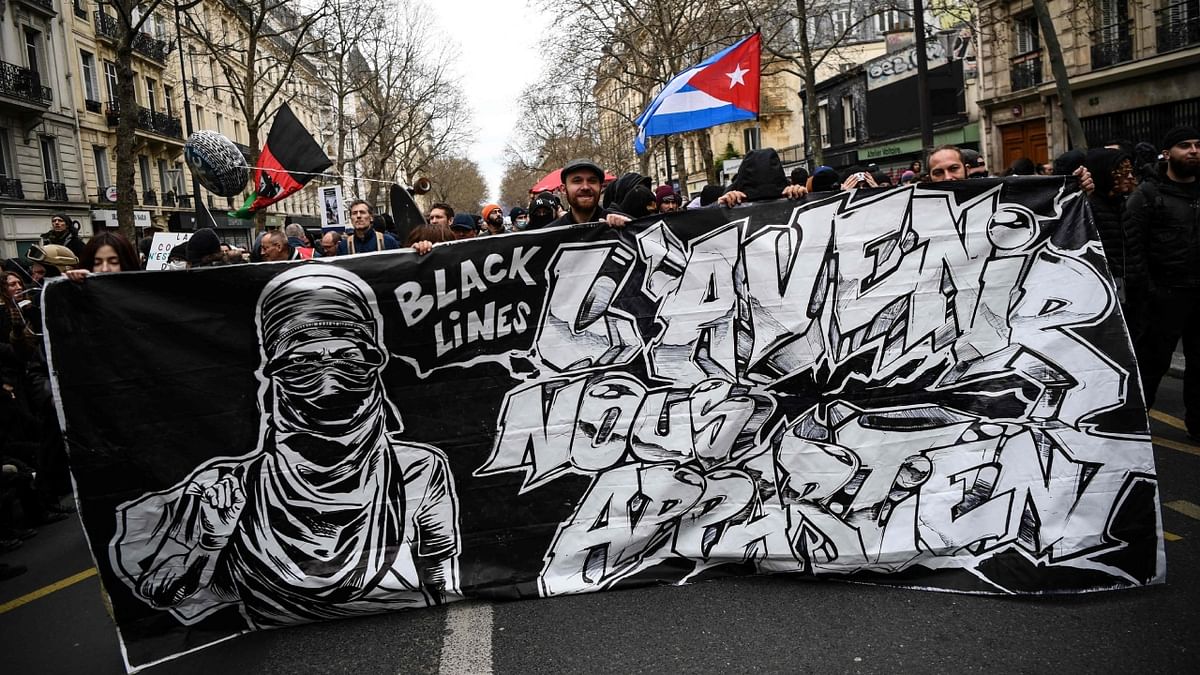 Protesters hold a banner reading 'Black lines, the future belongs to us' during a demonstration after the government pushed a pensions reform through parliament without a vote, using Article 49.3 of the constitution, in Paris. Credit: AFP Photo