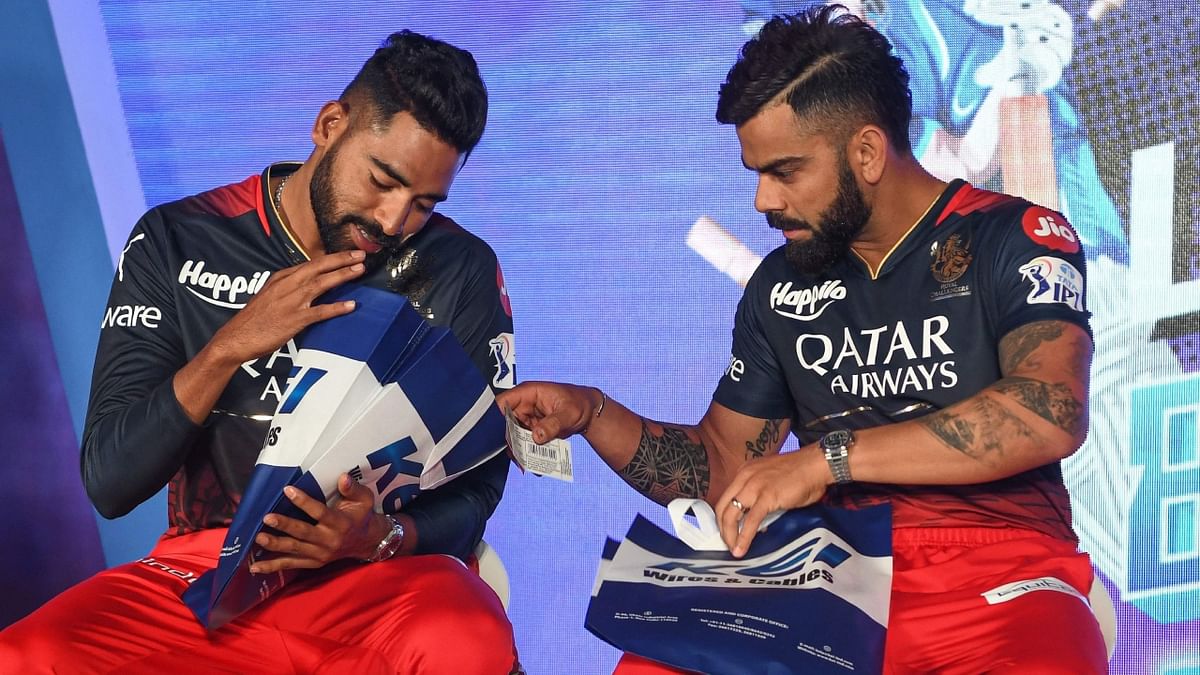 RCB players Mohammed Siraj and Virat Kohli get clicked during the launch of their team's new jersey in Bengaluru. Credit: AFP Photo