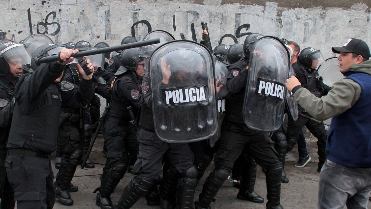 The Minister of Security of the province of Buenos Aires, Sergio Berni (covered by the police), is being protected and taken away by police officers after being beaten by a group of bus drivers protesting for the murder of a colleague in La Matanza, on the western outskirts of Buenos Aires. Credit: AFP Photo