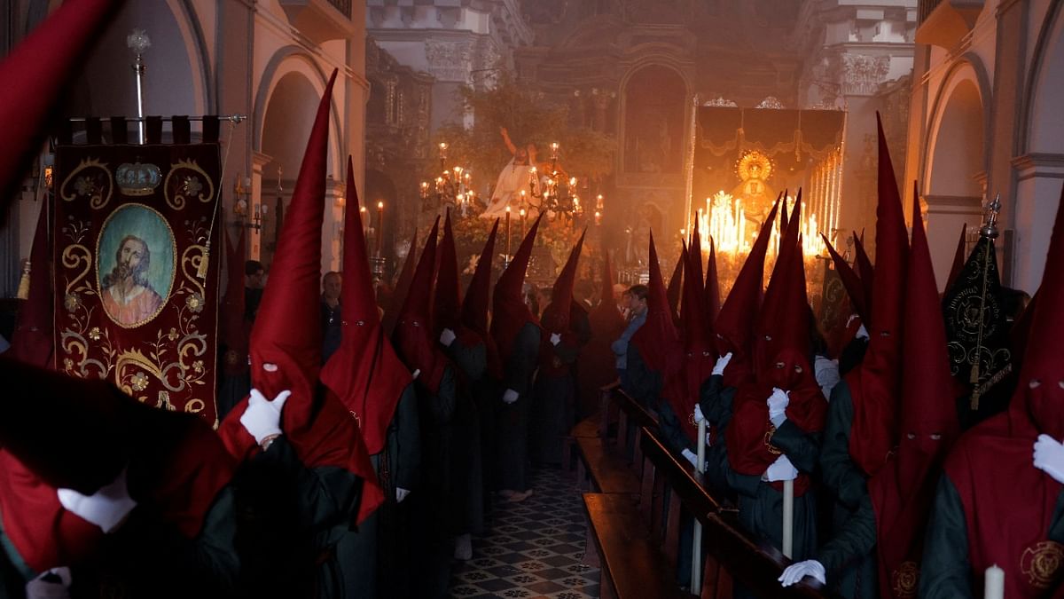 People acting as 'penitents' belonging to Huerto brotherhood leave a church as they take part in a procession in Ronda, Spain. Credit: Reuters Photo