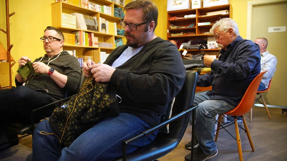 The 51-year-old Throwe, an office manager for a national association of nursing schools, puts some finishing touches on a brown sweater with a subtle golden pattern that he's been making on and off for years. Credit: AFP Photo