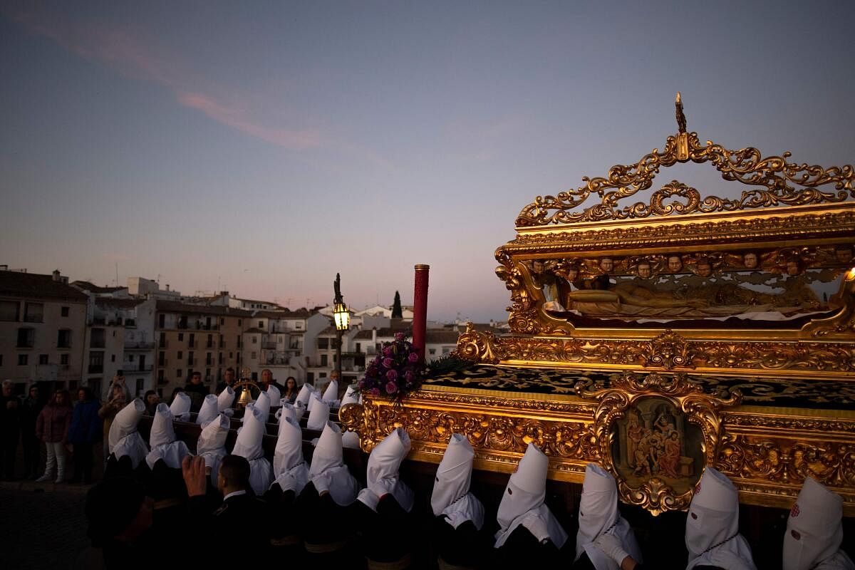 Penitents of the “Santo Entierro de Cristo” brotherhood bear a float with a statue of Christ in a coffin during the Good Friday procession in Ronda. Credit: AFP Photo