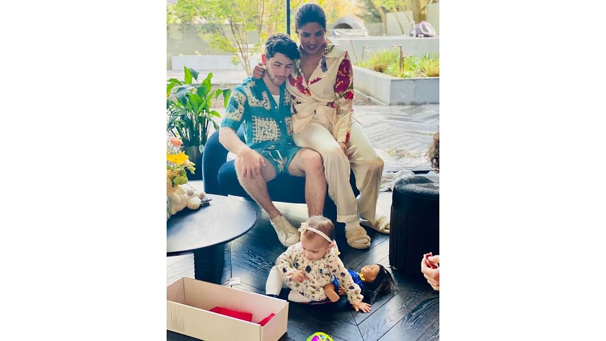 Nick Jonas shared an adorable family photo in which him and Priyanka can be seen looking at their daughter Malti, who is busy playing. Credit: Instagram/@nickjonas