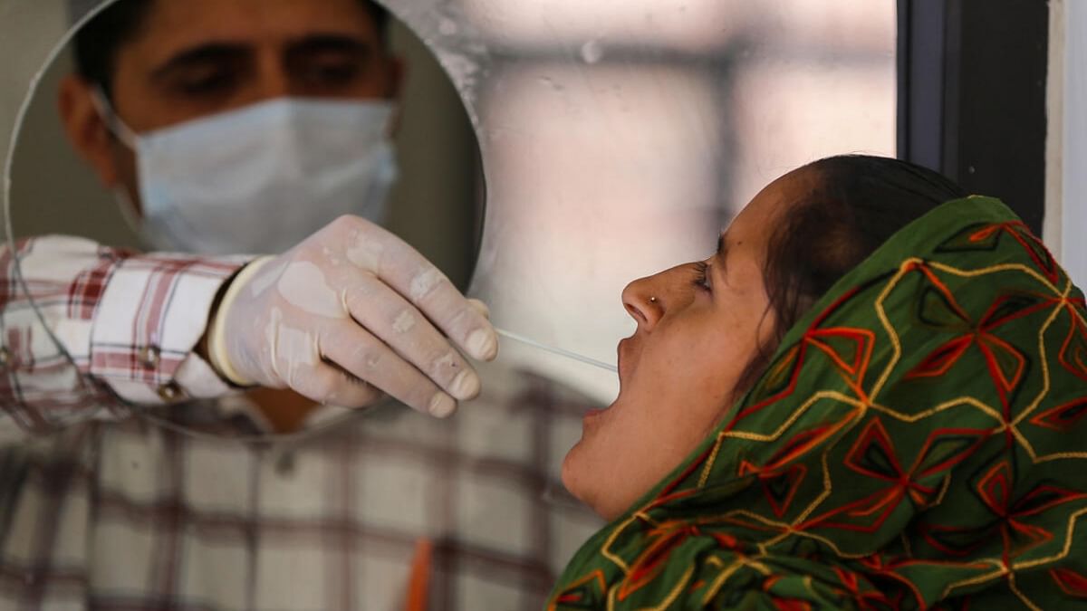 Jammu: A healthcare worker collects a swab sample of a woman for Covid-19 test, amid a rise in coronavirus cases in the country, in Jammu, Saturday, April 15, 2023. Credit: PTI Photo