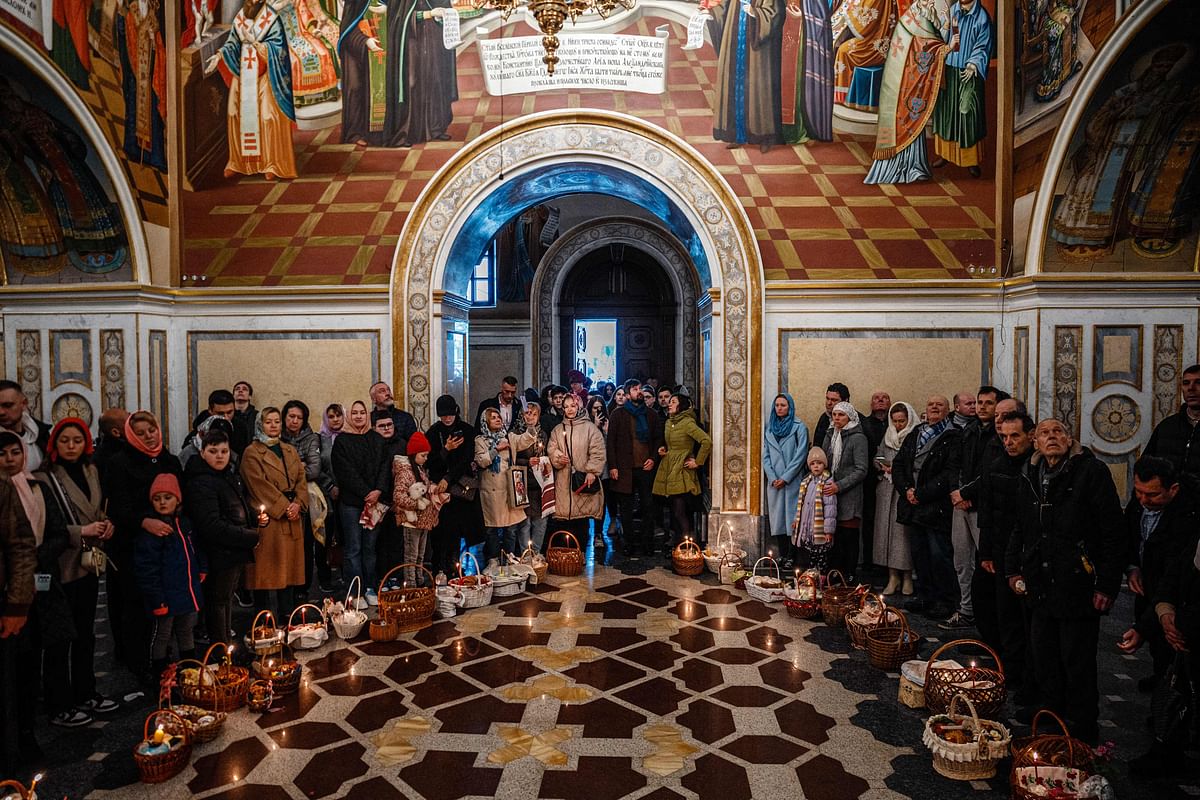 Worshippers stand next to their baskets with traditional Easter food and wait to be blessed during the celebration of the Orthodox Easter at the Dormition Cathedral in the medieval cave monastery of Kyiv Pechersk Lavra in Kyiv. Credit: AFP Photo