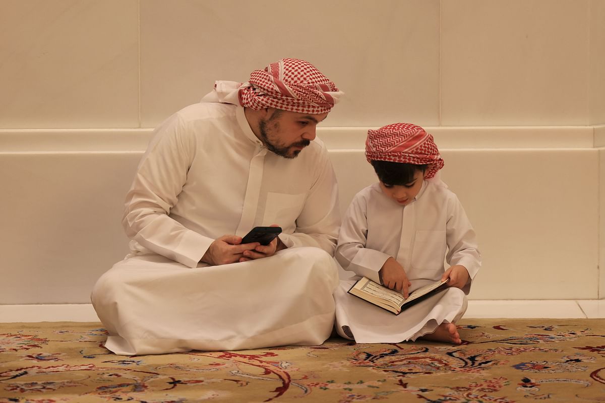 A child opens the Koran during prayers at the Sheikh Zayed Grand Mosque in Abu Dhabi. Credit: AFP Photo