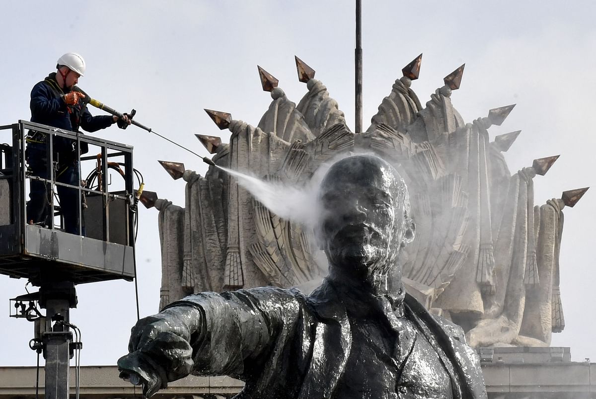 A worker cleans a statue of the founder of the Soviet Union Vladimir Lenin at Moscow Square in front of the House of Soviets in Saint Petersburg. Credit: AFP Photo