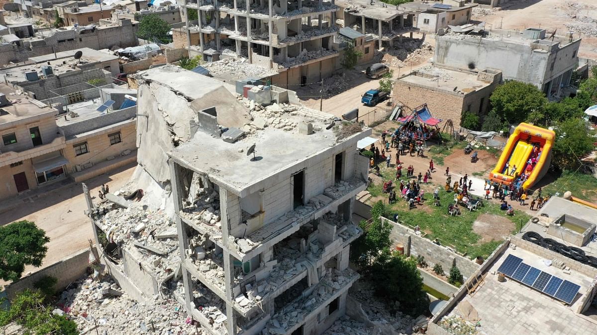 This aerial view shows a makeshift amusement parkset up for children amidst buildings damaged in the earthquake that shook Turkey and Syria in February. Credit: AFP Photo