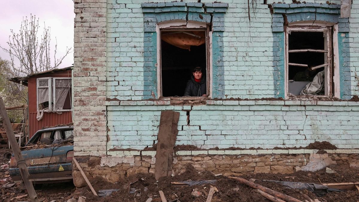 A local resident looks out from her partially destroyed house, after missile strikes, in the town of Kostyantynivka, Donetsk region. Credit: AFP Photo