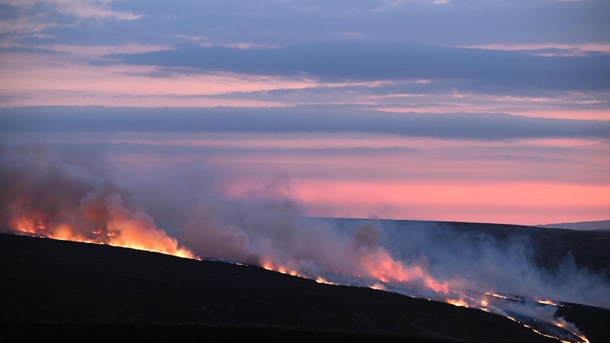 Smoke from a fire is blown across the moor as the sun sets near the village of Marsden in northern England. Credit: AFP Photo