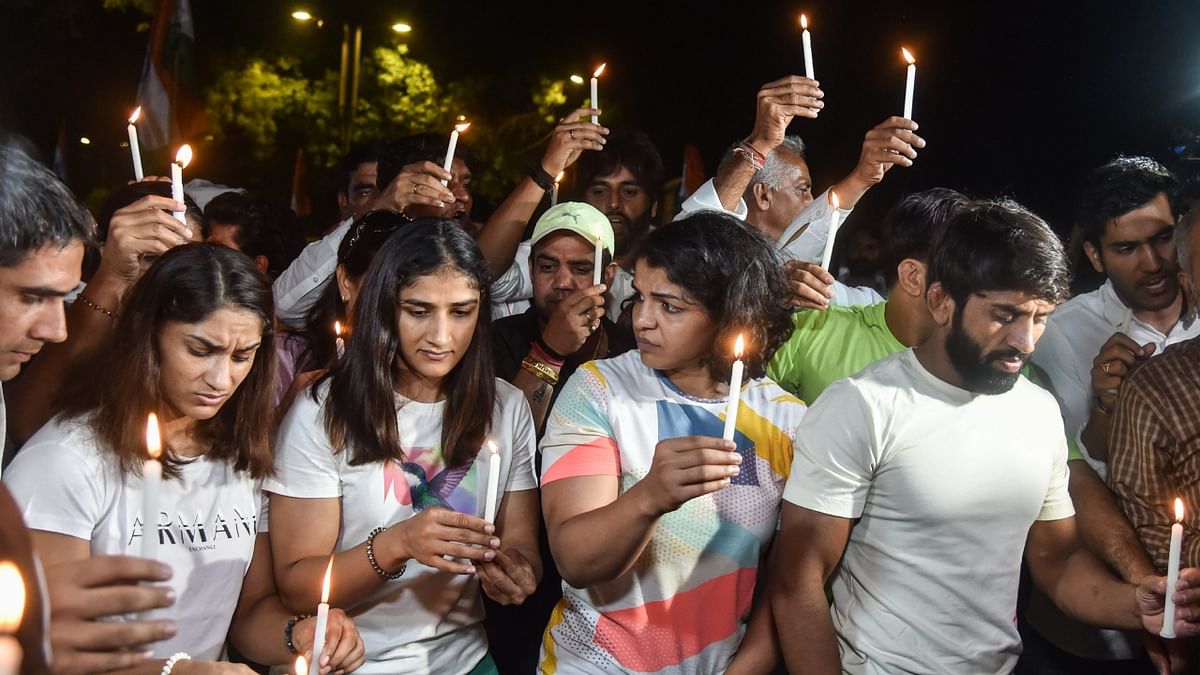 Wrestlers Bajrang Punia, Vinesh Phogat, Sakshi Malik and others participate in a candle march during their protest at Jantar Mantar, in New Delhi. Credit: PTI Photo