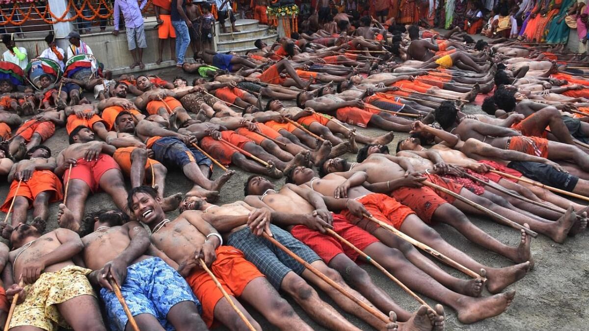 Hindu devotees lie on the ground as they wait for blessings from a priest to have good crop, prosperity and peace during the 'Manda Puja' festival outside the Hindu Lord Shiva Temple in Ranchi on May 5, 2023. Credit: AFP Photo