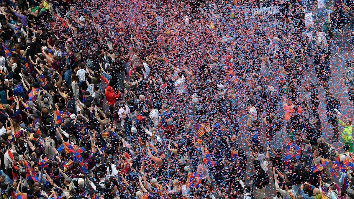 Players from both squads went on an open-bus parade through the Catalan capital on Monday (May 15), greeting fans who sang and waved flags while fireworks and confetti were set off. Credit: AFP Photo