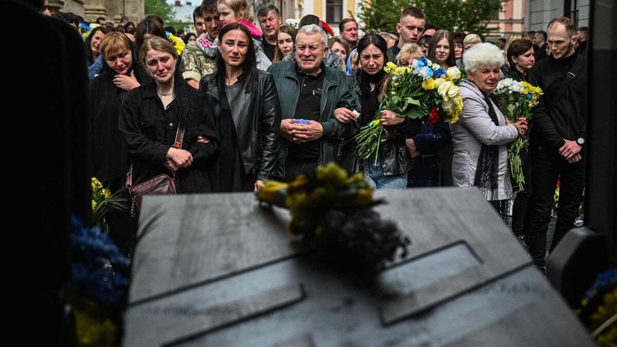 Relatives and friends mourn next to the coffin of Ukrainian serviceman Volodymyr Nestor, killed in combat with Russian troops, during his funeral in Lviv on May 16, 2023, amid the Russian invasion of Ukraine. Credit: AFP Photo