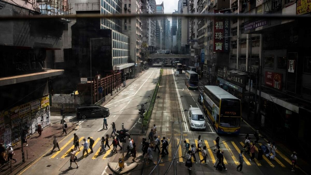 Pedestrians cross the street at the Causeway Bay district of Hong Kong on May 19, 2023. Credit: AFP Photo