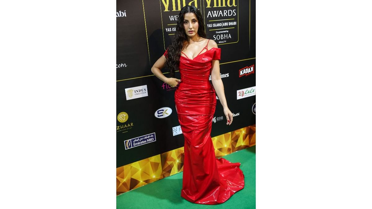 Nora Fatehi made heads turn with her look at the ongoing IIFA 2023 in Yas Island, Abu Dhabi. She walked the ramp in a fiery red latex gown. Credit: AFP Photo