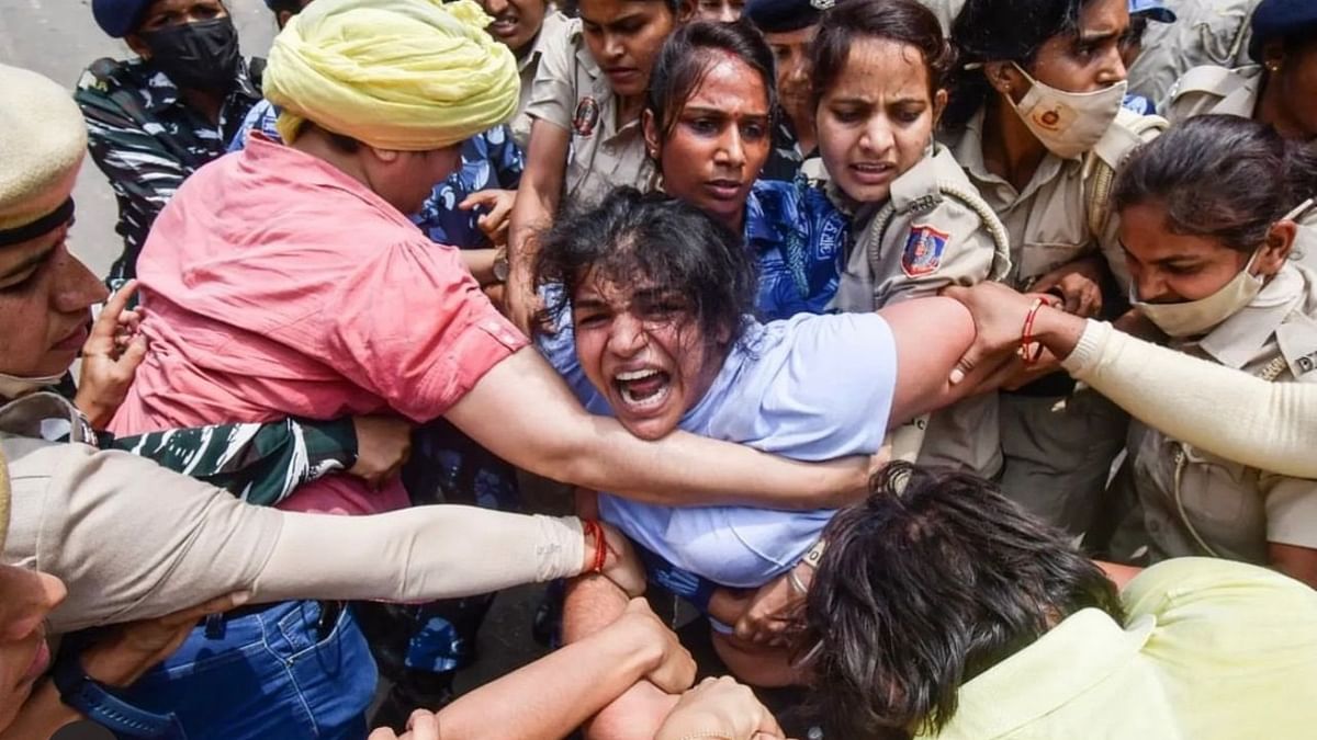 Wrestler Sakshi Malik being detained by police during wrestlers' protest march towards new Parliament building, in New Delhi. Credit: IANS Photo