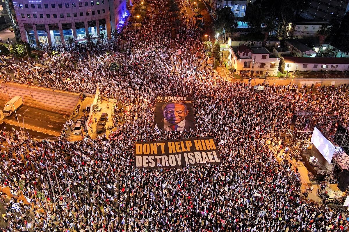 An aerial view shows protesters holding signs, one which depicts Israeli Prime Minister Benjamin Netanyahu and the other with the words