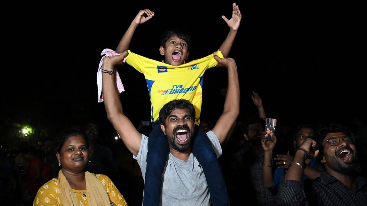 Chennai Super Kings' fans celebrate their team's win at the end of the Indian Premier League (IPL) Twenty20 final cricket match between Gujarat Titans and Chennai Super Kings, at a drive-in theatre live streaming the match in Chennai. Credit: AFP Photo