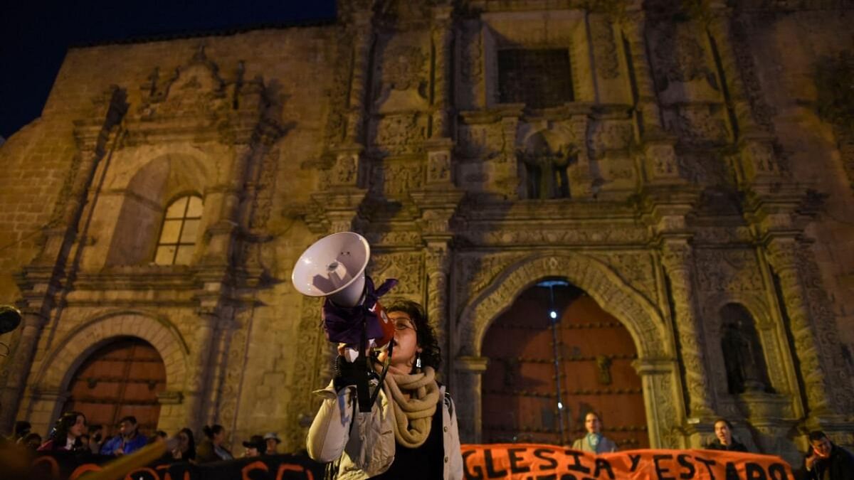 A woman yells using a megaphone in front of the Basilica de San Francisco during a protest against the Catholic Church following abuse allegations, in La Paz, Bolivia, June 2, 2023. Credit: Reuters Photo