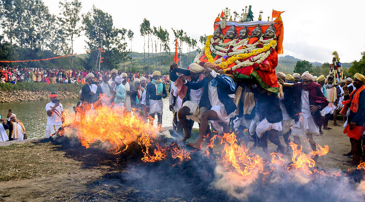 Devotees cross a fire performing a ritual during celebrations of the festival of 'Suggi Habba', in Chikmagalur. Credit: PTI Photo