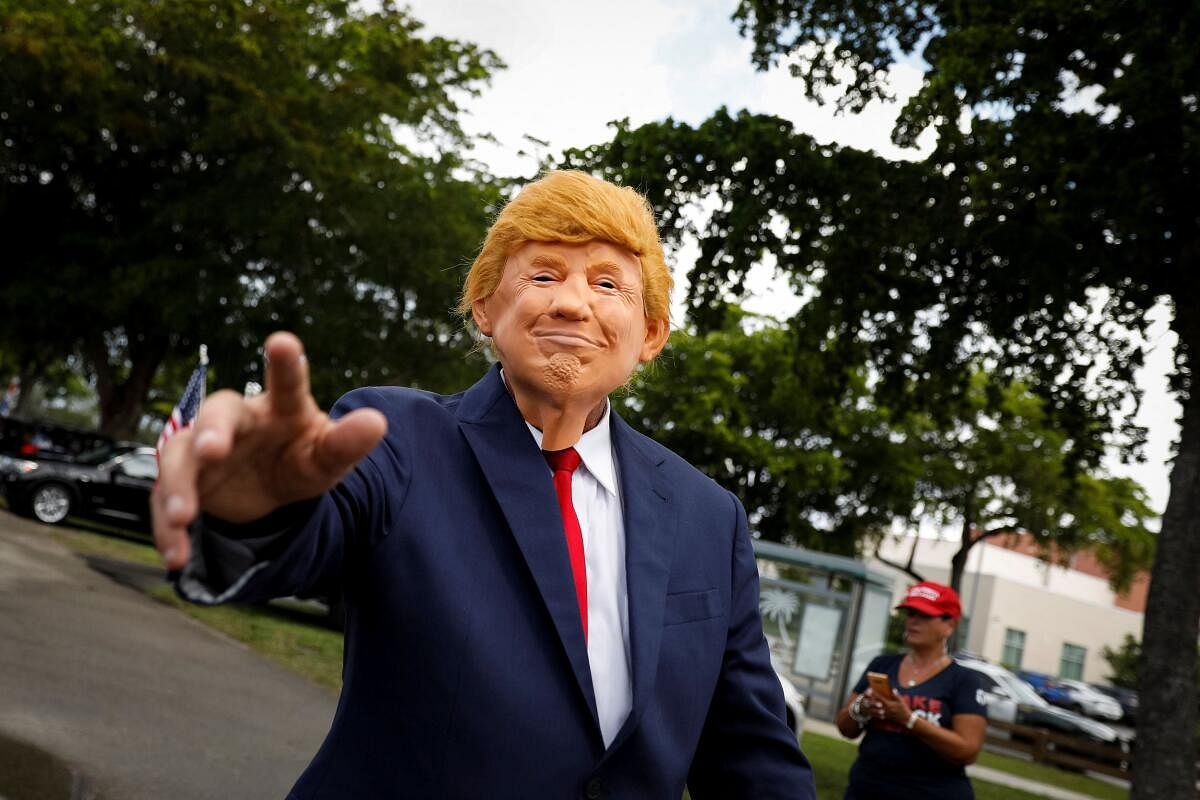 Raul Meneses wears a mask depicting former U.S. President Trump during a gathering at Tropical Park, as he is to appear in a federal court on classified document charges, in Miami, Florida. Credit: Reuters Photo