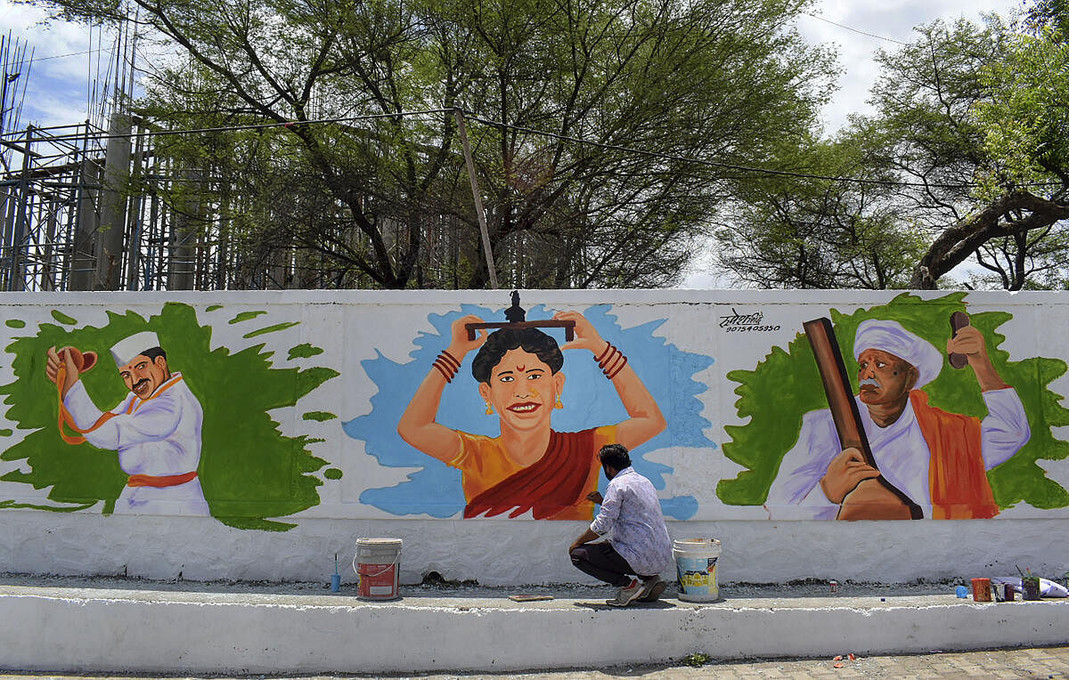 An artist makes graffitis on the walls along the Vishrantwadi road, in Pune. Credit: PTI Photo