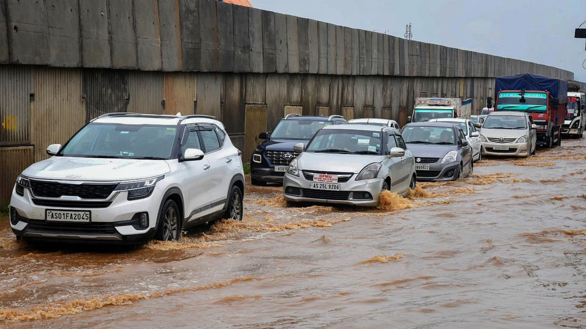 Vehicles wade through the waterlogged National Highway 27 after rainfall, at Boragaon in Guwahati. Credit: PTI Photo