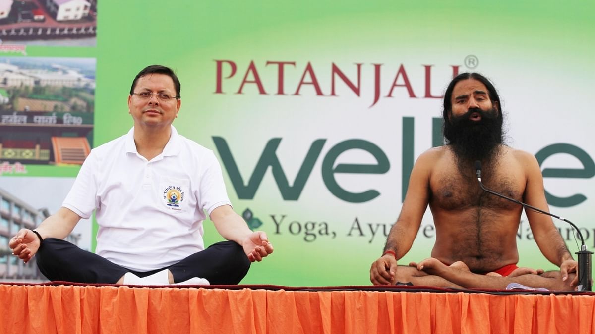 Uttarakhand Chief Minister Pushkar Singh Dhami with Baba Ramdev, performing yoga at a programme organised on the International Day of Yoga in Haridwar. Credit: IANS Photo