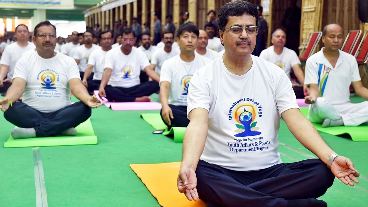 Tripura CM Manik Saha along with other ministers, government officials and students perform yoga during a session on the 'International Day of Yoga' celebrations in Agartala. Credit: IANS Photo