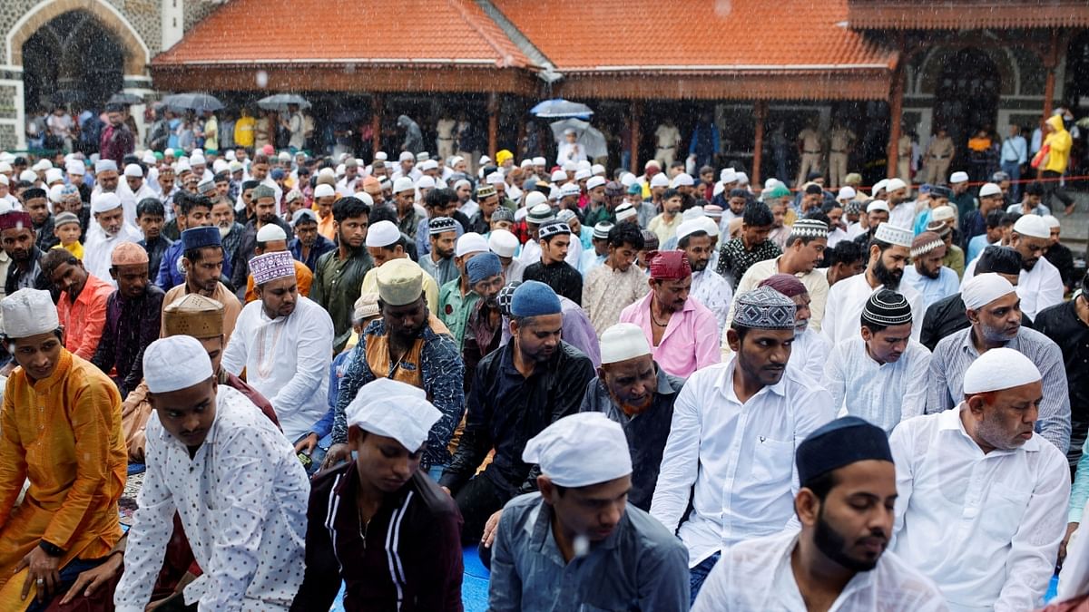 Muslims offer prayers outside a railway station on the occasion of Eid al-Adha festival on a rainy day in Mumbai. Credit: Reuters Photo