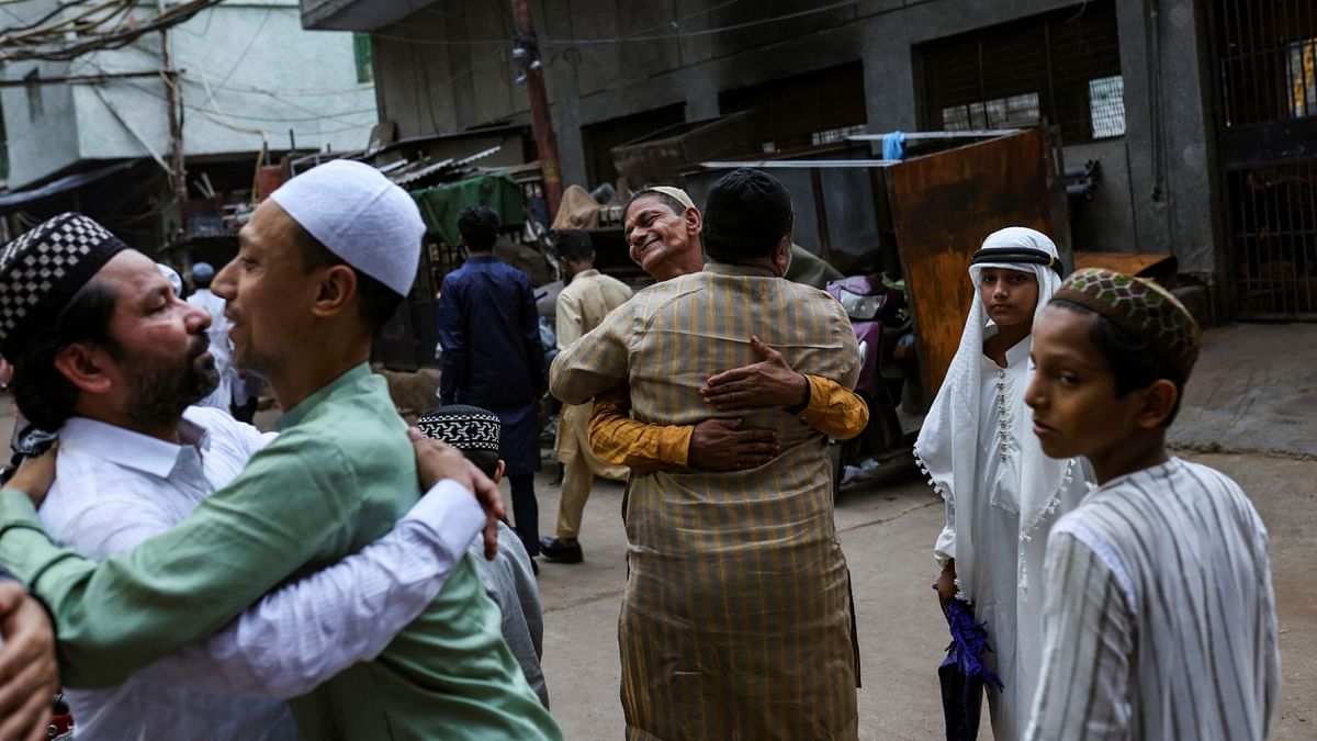 Muslim men greet each other on the occasion of Eid al-Adha festival, in the old quarters of Delhi. Credit: Reuters Photo