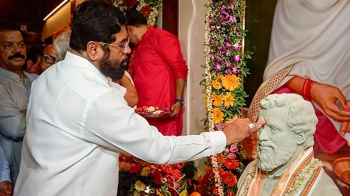 Maharashtra Chief Minister Eknath Shinde pays respects to Anand Dighe on the occasion of Guru Purnima, at Shiv Sena Shakha, in Thane. Credit: PTI Photo