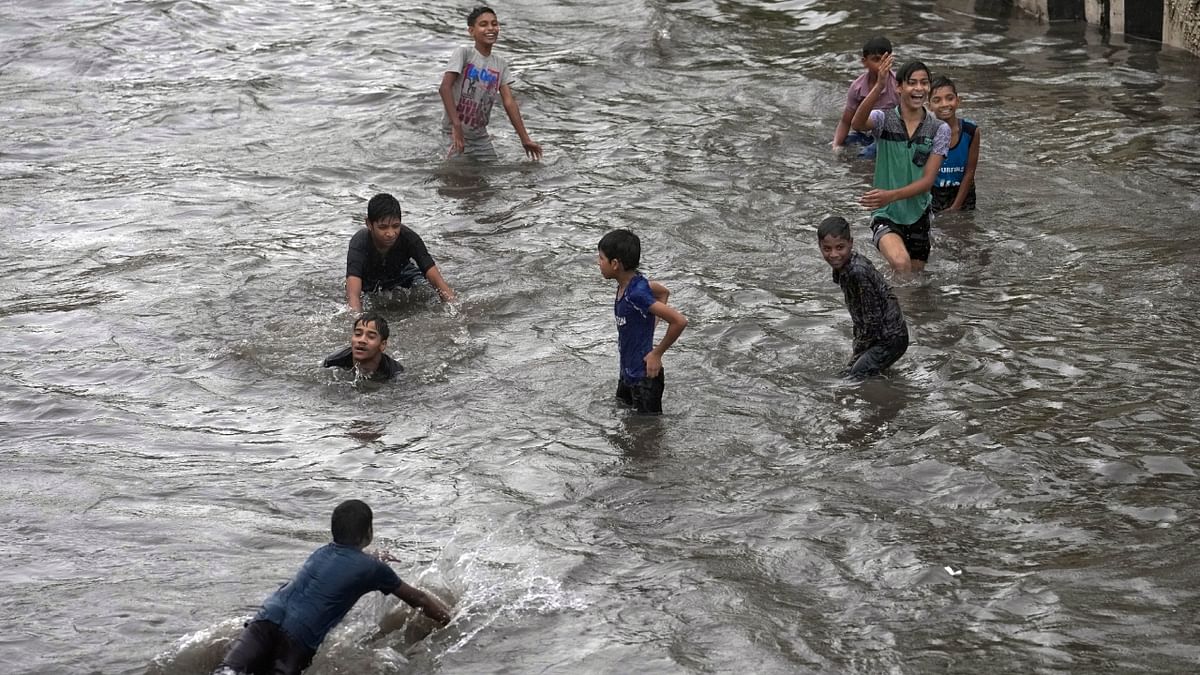Children play on a waterlogged road amid monsoon rains, in New Delhi. Credit: PTI Photo