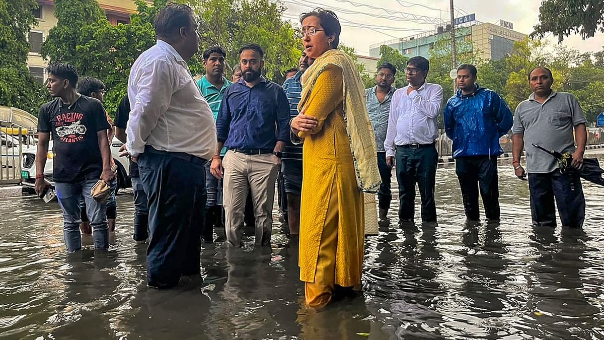 Delhi Education and PWD Minister Atishi interacts with locals during the inspection of the waterlogged areas after heavy monsoon rains, near ITO in New Delhi. Credit: Twitter/@AtishiAAP